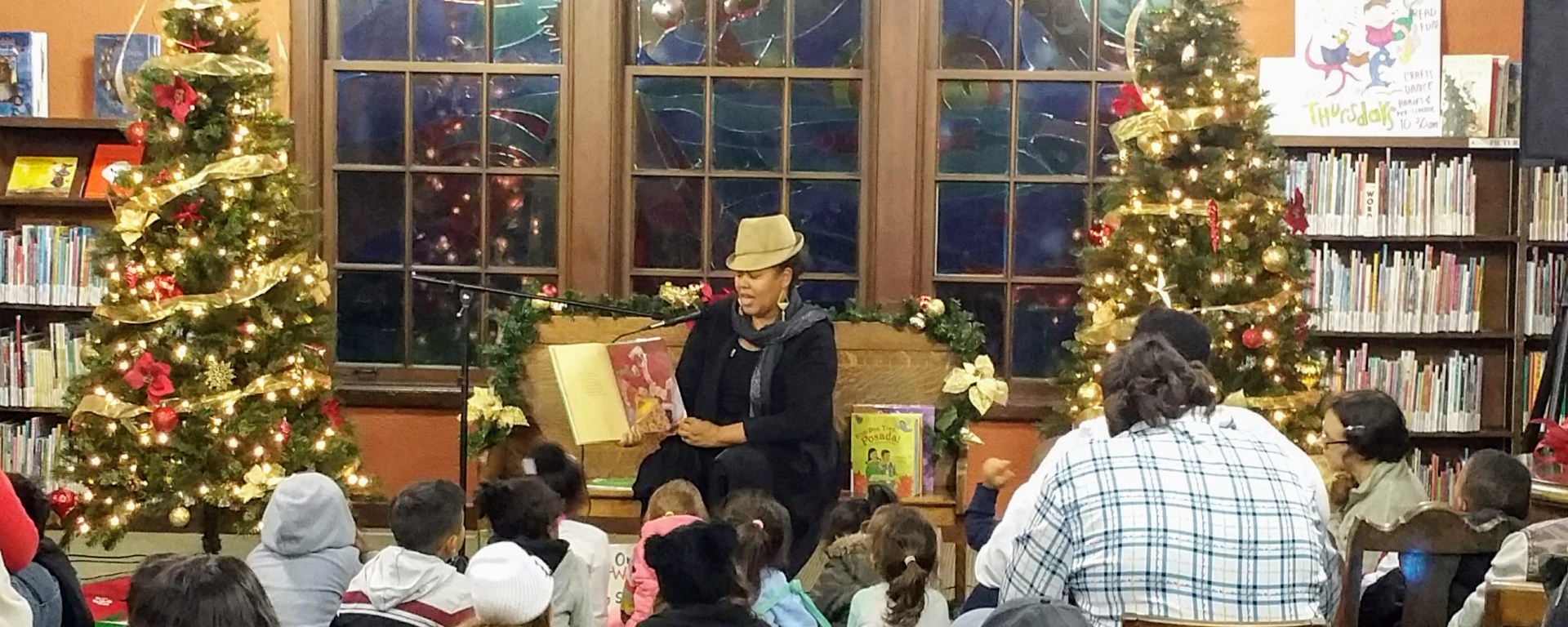 woman wearing hat reading to audience